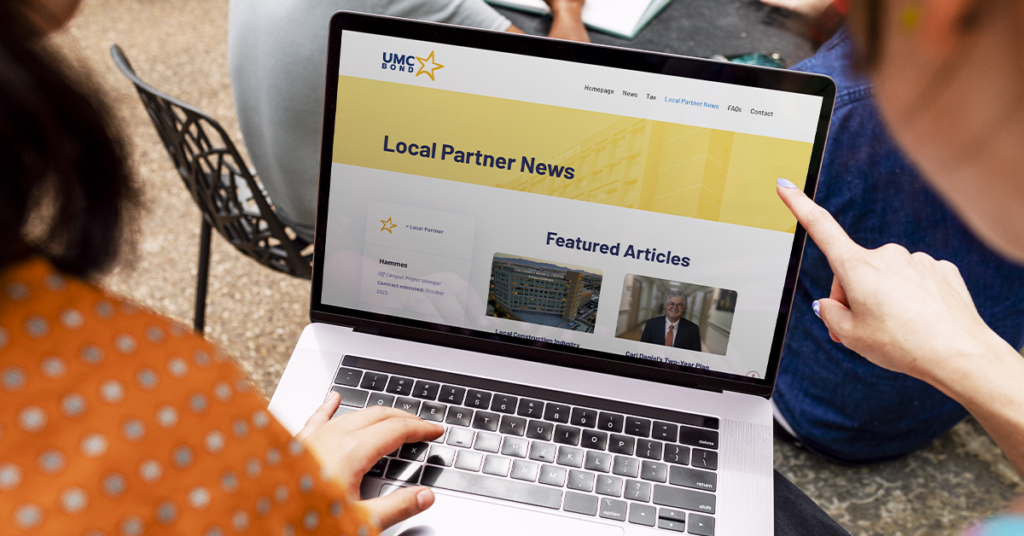 Persona navegando el sitio web de UMC Bond en una laptop, representando alianzas locales para el desarrollo de proyectos de infraestructura